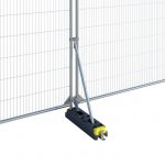 The image shows a small stabiliser, model HSG151. It consists of a long, slender metal bracket with a right-angled bend at one end and multiple holes for screws or bolts along its length. The metal is galvanized steel, indicating durability and resistance to corrosion. The image demonstrated how the stabiliser systems is to be installed. The stabiliser is designed to provide additional support and stability to temporary fencing systems, ensuring safety and durability in various environments.