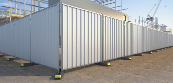 The image shows a series of vertical hoarding panels with a corrugated metal surface, set up around a construction site.